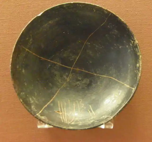 Cross on a black dish with graffiti design